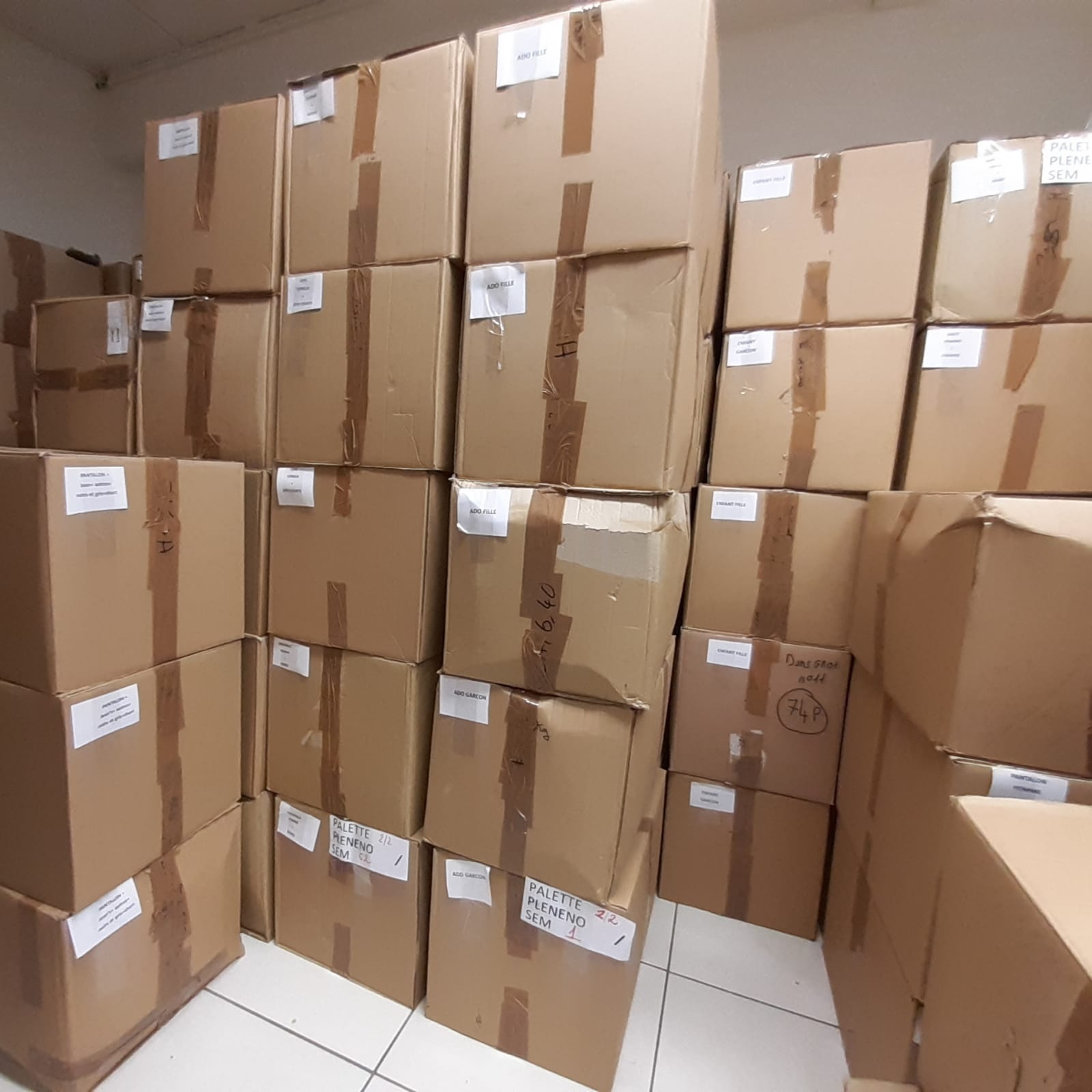 Pile de cartons en réserve, prêt à être déballé pour vous proposer quotidiennement de nouveaux vêtements en rayon.